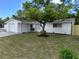 Newly renovated home with a white brick exterior and a spacious lawn at 7329 Heather St, New Port Richey, FL 34653