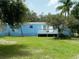 Single-wide mobile home with a blue exterior and deck at 11911 Rhodine Rd, Riverview, FL 33579