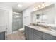 Bathroom featuring double sinks, granite countertops, and a glass-enclosed shower at 1321 Bluewater Dr, Sun City Center, FL 33573