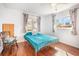 Bedroom with wood-look floors and natural light and chair at 1321 Bluewater Dr, Sun City Center, FL 33573