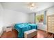 Bright bedroom featuring two beds, ceiling fan, wood-look floors, and a window for natural light at 1321 Bluewater Dr, Sun City Center, FL 33573