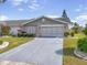 Charming home featuring a two-car garage, stone accents, and well-maintained landscaping at 1321 Bluewater Dr, Sun City Center, FL 33573