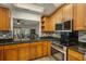 Well-equipped kitchen with wood cabinets, granite countertops, and stainless steel appliances at 1321 Bluewater Dr, Sun City Center, FL 33573
