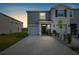 Two-story townhome with gray exterior, two-car garage, and landscaping at 16701 Maude Dr, Wimauma, FL 33598