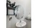 Small bathroom with pedestal sink, oval mirror, and floating shelves at 16701 Maude Dr, Wimauma, FL 33598
