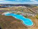 Aerial view showing a crystal-clear lagoon pool and surrounding community at 16701 Maude Dr, Wimauma, FL 33598