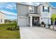 Townhome with gray exterior, two-car garage, and front landscaping at 16701 Maude Dr, Wimauma, FL 33598