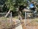 Front yard with gate and mature trees at 6408 River Ridge Rd, New Port Richey, FL 34653