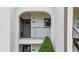 Private condo entrance with a balcony and lush green shrub at 7701 Starkey Rd # 324, Seminole, FL 33777