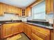 Modern kitchen with wood cabinets, granite countertops, and a microwave at 7701 Starkey Rd # 324, Seminole, FL 33777