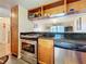 Updated kitchen with wood cabinets, granite countertops, and stainless steel appliances at 7701 Starkey Rd # 324, Seminole, FL 33777