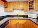 Modern kitchen featuring wood cabinets, granite countertops, and a microwave at 7701 Starkey Rd # 324, Seminole, FL 33777