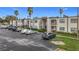Exterior view of a condo building with ample parking and lush landscaping at 7701 Starkey Rd # 324, Seminole, FL 33777