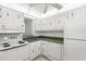 Compact kitchen featuring white appliances, cabinets, and ample counter space for food preparation at 11485 Oakhurst Rd # 322, Largo, FL 33774