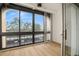 Bright living room with wood floors with expansive windows offering views of the parking area at 11485 Oakhurst Rd # 322, Largo, FL 33774