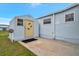 Inviting storage shed with yellow door and concrete patio at 122 E Saint Johns Way, Apollo Beach, FL 33572