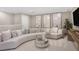 Spacious Gathering room with a curved sofa and plenty of natural light at 4351 Cloud Hopper Way, Lutz, FL 33559