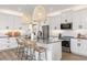 Modern kitchen with white cabinets, gray countertops, and a large island at 4357 Cloud Hopper Way, Lutz, FL 33559