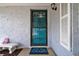 Inviting teal front door with a security gate and a welcoming doormat at 7511 Tyson Dr, Port Richey, FL 34668