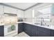Bright kitchen featuring white and dark blue cabinets, updated sink and stove at 7511 Tyson Dr, Port Richey, FL 34668