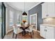 Bright breakfast nook with a wooden table and white cushioned chairs at 8520 Grand Alberato Rd, Tampa, FL 33647
