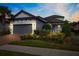 Attractive single-story home with a gray garage door and landscaping at 8520 Grand Alberato Rd, Tampa, FL 33647