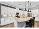 Modern kitchen with white cabinets, granite countertops, and an island with seating at 8520 Grand Alberato Rd, Tampa, FL 33647
