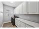 Bright laundry room with white cabinets and plenty of storage at 8520 Grand Alberato Rd, Tampa, FL 33647