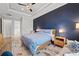 Main bedroom with a wooden bed, blue bedding, and a view of the backyard at 8520 Grand Alberato Rd, Tampa, FL 33647
