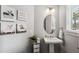 Stylish powder room with pedestal sink and oval mirror at 8520 Grand Alberato Rd, Tampa, FL 33647