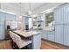 Modern kitchen with light blue cabinets, granite island, and stainless steel appliances at 3506 N Arlington Ave, Tampa, FL 33603