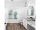 Bathroom featuring wood-look floors, white trim, a window, and a vanity at 3506 N Arlington Ave, Tampa, FL 33603