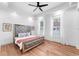Bright bedroom featuring wood floors, a ceiling fan, and a luxurious upholstered bed at 3506 N Arlington Ave, Tampa, FL 33603