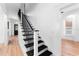 Stylish staircase with black metal railing and hardwood floors at 3506 N Arlington Ave, Tampa, FL 33603