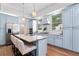 Charming kitchen features light blue cabinetry, granite counters, a stainless fridge, and an island with seating at 3506 N Arlington Ave, Tampa, FL 33603