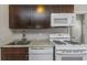 Modern kitchen with white appliances and dark brown cabinets at 4601 8Th N Ave, St Petersburg, FL 33713