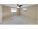 Well-lit bedroom with ceiling fan and two windows at 5026 Flora Ave, Holiday, FL 34690