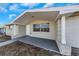 Front porch entry to a light beige home with white columns at 5026 Flora Ave, Holiday, FL 34690