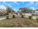 Ranch-style home with attached two-car garage and palm trees at 615 16Th Nw St, Largo, FL 33770