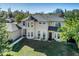 Two-story house with gray roof, light beige walls, and a landscaped yard at 7700 N Highland Ave, Tampa, FL 33604