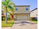 Tan two-story house with red door and palm tree at 20028 Satin Leaf Ave, Tampa, FL 33647