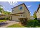 Tan two-story house with a two-car garage and landscaping at 20028 Satin Leaf Ave, Tampa, FL 33647