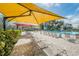 Pool area with yellow and red shade umbrellas and lounge chairs at 2430 Florentine Way # 40, Clearwater, FL 33763