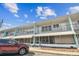 Inviting two-story building with awnings and car parked in front of it against a blue sky at 4152 55Th N Way # 1028, Kenneth City, FL 33709