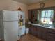 A galley kitchen with wood cabinets, double sink, and refrigerator at 5748 Montana Ave, New Port Richey, FL 34652