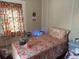 Small bedroom with full-size bed and floral bedding at 5748 Montana Ave, New Port Richey, FL 34652