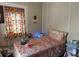 Small bedroom with full-size bed and floral bedding at 5748 Montana Ave, New Port Richey, FL 34652