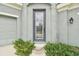 Modern front door with glass panels and a rainbow doormat at 6317 Brevada Ln, Apollo Beach, FL 33572