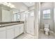 Bright bathroom featuring a granite-topped vanity, glass-enclosed shower, and modern toilet at 6317 Brevada Ln, Apollo Beach, FL 33572