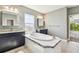 Bathroom featuring a soaking tub with tile surround and double vanities at 6317 Brevada Ln, Apollo Beach, FL 33572